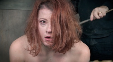 Natural redhead Kel Bowie is stripped to knee socks before torture session