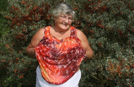 Obese nan Grandma Libby strips totally naked out by evergreen trees