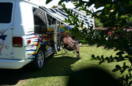 Mature blonde Mary Bitch shows her big tits and pussy outside a B class camper