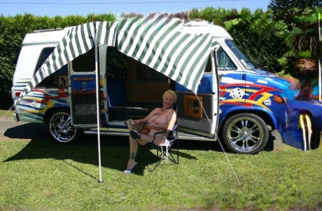 Mature blonde Mary Bitch shows her big tits and pussy outside a B class camper