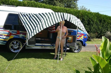 Mature blonde Mary Bitch shows her big tits and pussy outside a B class camper