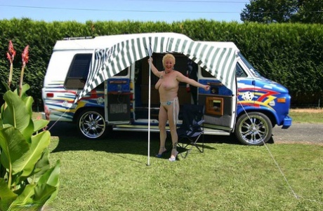Mature blonde Mary Bitch shows her big tits and pussy outside a B class camper