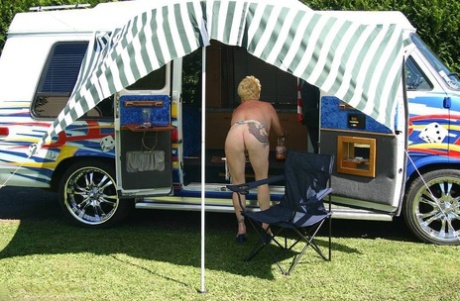 Mature blonde Mary Bitch shows her big tits and pussy outside a B class camper