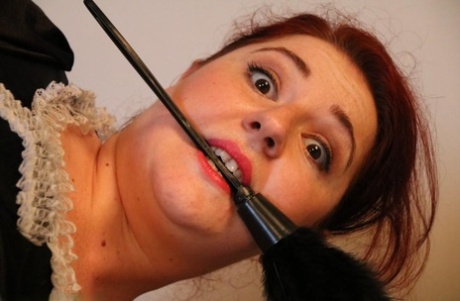Natural redhead is left tied up on a bed in her maid uniform