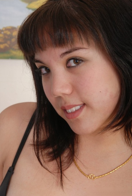 Chubby Latina girl with a pretty face removes black lingerie to pose nude
