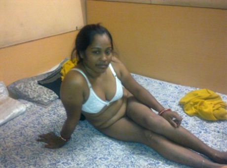 Chubby Indian chick gets completely naked on top of her bed