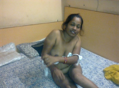 Chubby Indian chick gets completely naked on top of her bed
