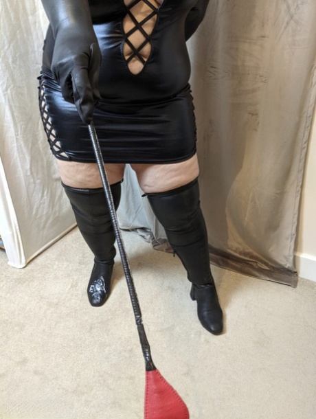 Older redhead Mrs Leather smacks her bald twat with crop in latex attire