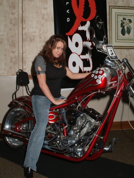 Brandy Talore straddles a motorcycle before showing her huge tits and pussy