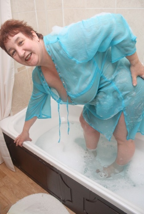 Redhead nan Kinky Carol shows her big ass and snatch in a bathtub