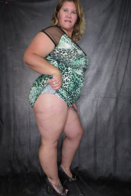 Obese amateur Busty Kris Ann takes of a dress and thong to model naked