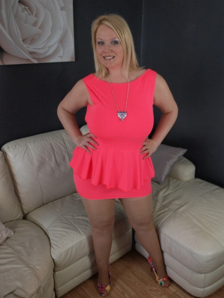 Thick amateur Sindy Bust teases on leather furniture in a short pink dress