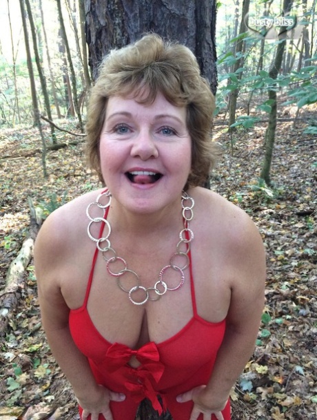 Older amateur Busty Bliss displays her big natural tits while nude in a forest