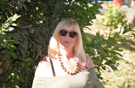 Fat blonde Melody fondles her breasts while outdoors in sunglasses
