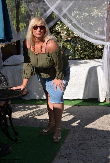 Fat blonde Melody fondles her breasts while outdoors in sunglasses