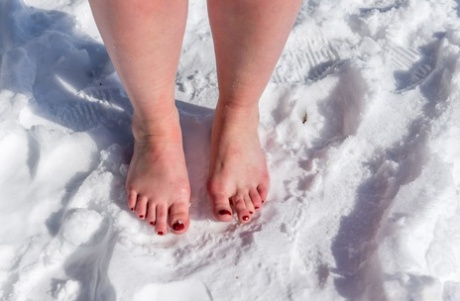BBW solo girl is ball gagged and bound on snow-covered ground in the nude
