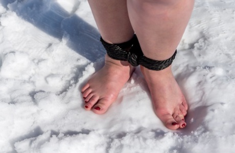 BBW solo girl is ball gagged and bound on snow-covered ground in the nude