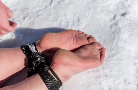 BBW solo girl is ball gagged and bound on snow-covered ground in the nude