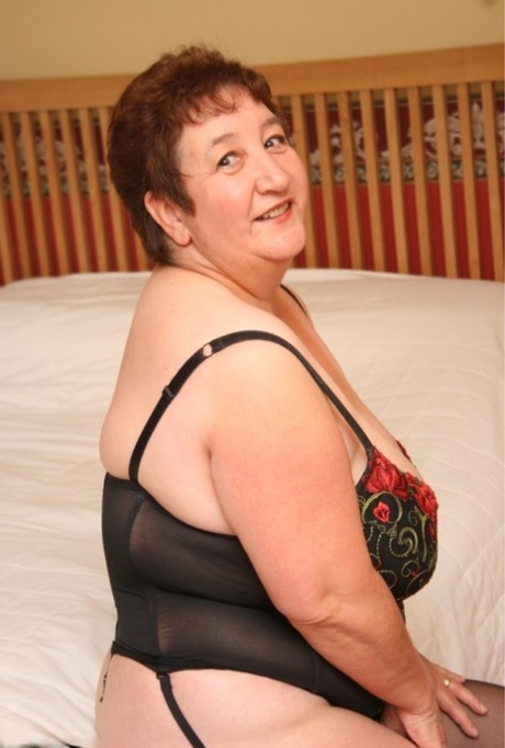 Overweight British woman Kinky Carol shows her big boobs and butt on a bed