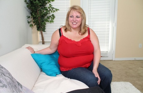 Fat blonde woman holds her large breasts after giving a blowjob
