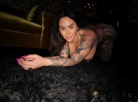 Curvy brunette Drea Alexa displays her tattooed body in a black bikini