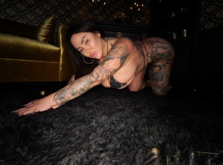 Curvy brunette Drea Alexa displays her tattooed body in a black bikini