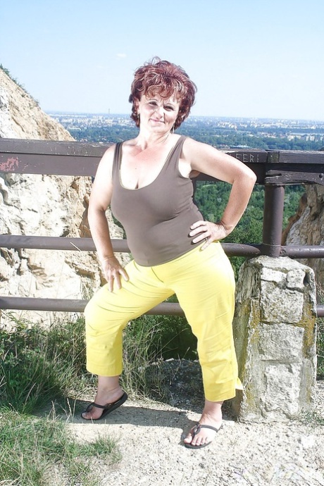 Naughty granny uncovering her fatty body with flabby boobs outdoor