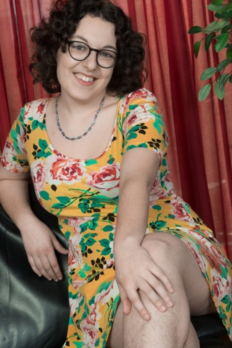 Girl with big tits and glasses Tamar reveals her hairy legs and twat on a sofa