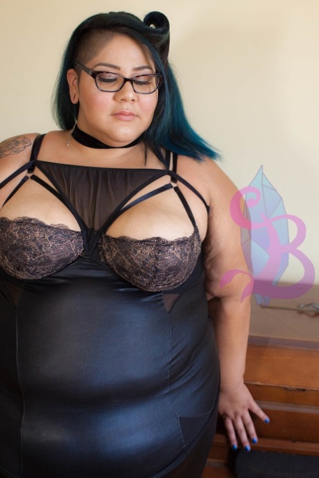 Tattooed SSBBW Crystal Blue teasing with her juicy natural tits in glasses