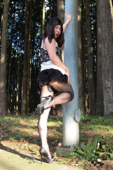 Tall shemale exposes her dick while teasing in pantyhose & high heels outdoors