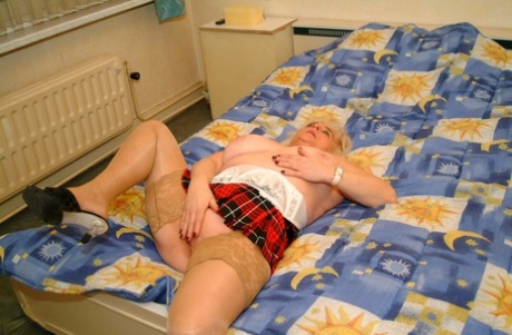 Mature Dutch housewife Henrietta posing in her top, stockings and short skirt