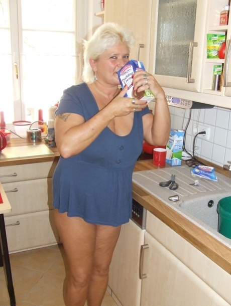 Fat blonde granny Katja pours chocolate milk all over her big tits in the tub